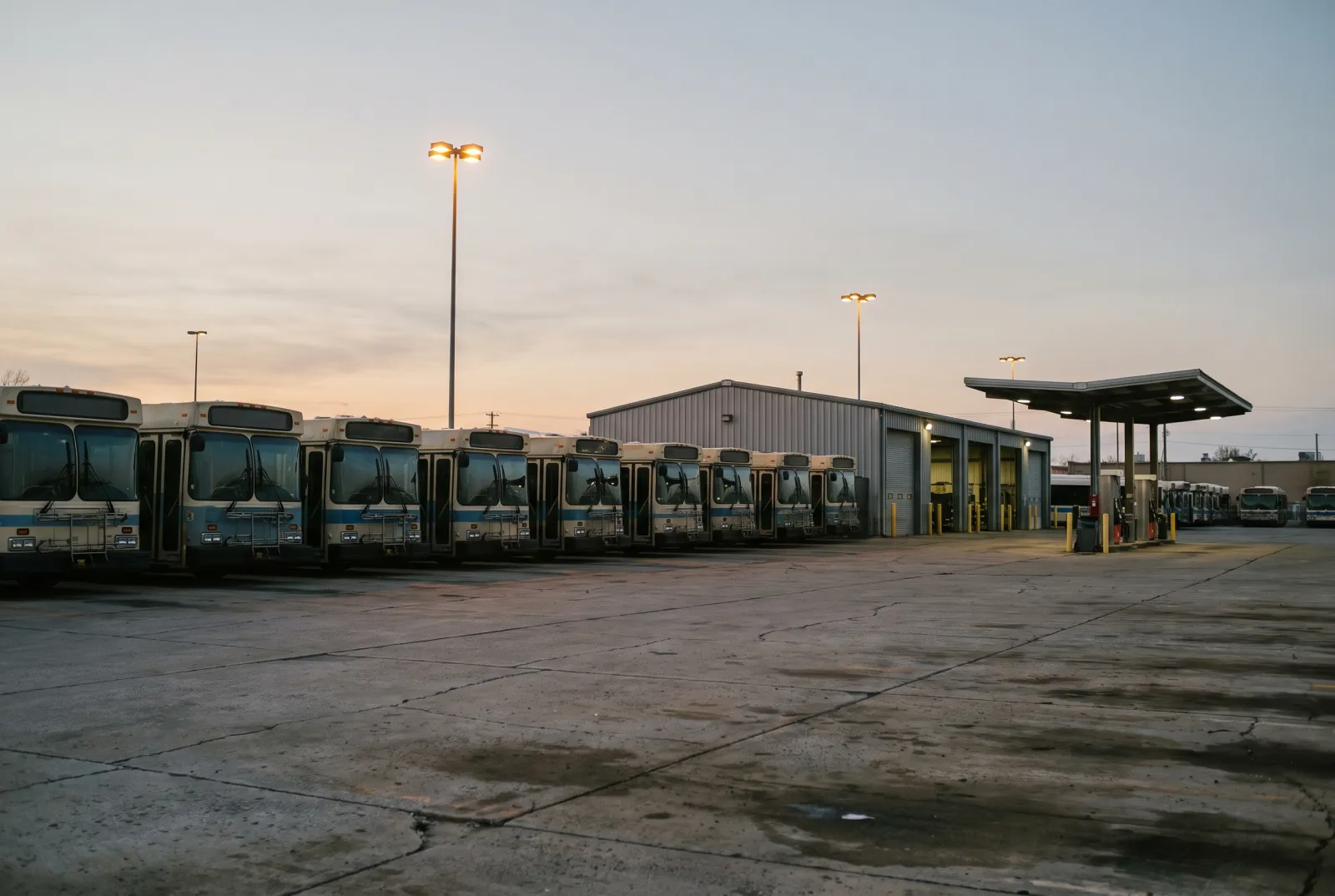 A government bus depot at dawn, buses lined up before service